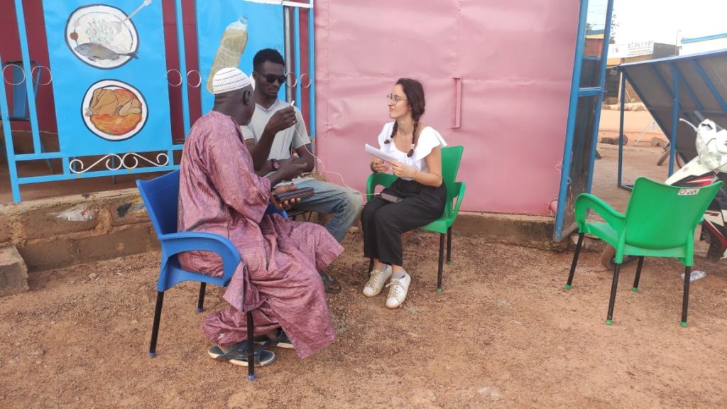 Giulia, della squadra Mani Tese, mentre intervista Hamidou e suo figlio Adboulaye.